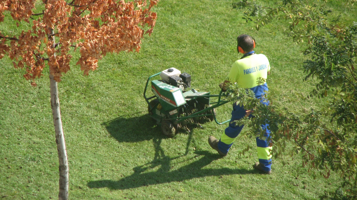 Pracownik z aeratorem na trawniku