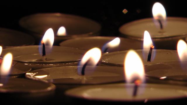 Płonące podgrzewacze tealight w ciemności